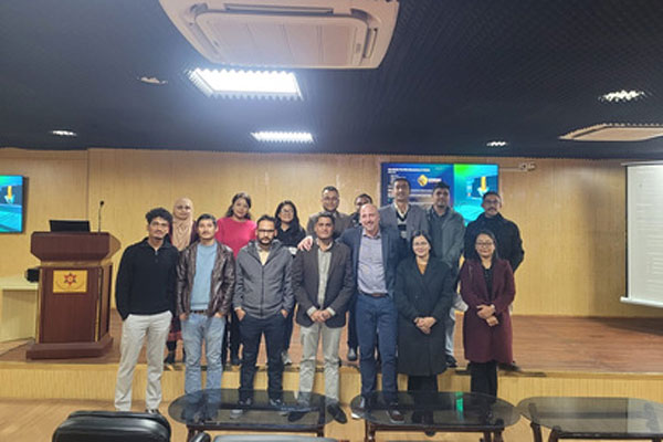A group of medical professionals and students posing for a photo on a stage in a lecture hall.