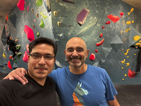 Two men posing in front of an Olympia Orthopaedic Associates lobby sign.