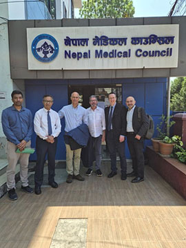 Group of six men posing outside the Nepal Medical Council entrance.